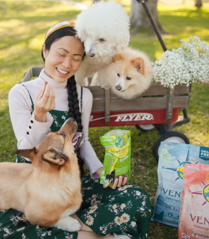 Young woman feeding her dogs Earthborn Holistic treats. 